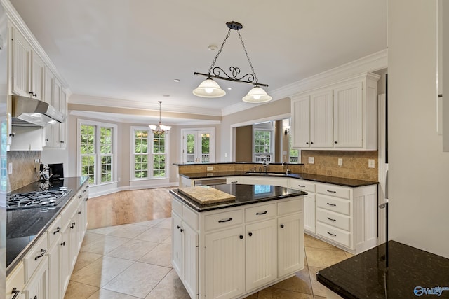 119 Railway Ln SE, Huntsville, AL 35803 - kitchen featuring appliances with stainless steel finishes, under cabinet range hood, light tile patterned floors, backsplash, and crown molding