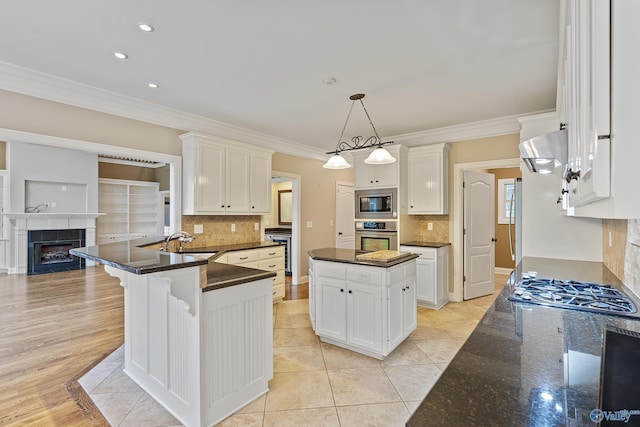 119 Railway Ln SE, Huntsville, AL 35803 - kitchen with stainless steel appliances, extractor fan, crown molding, a sink, and white cabinetry
