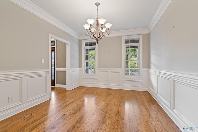 119 Railway Ln SE, Huntsville, AL 35803 - unfurnished dining area with a chandelier, ornamental molding, a wainscoted wall, and light wood-style flooring