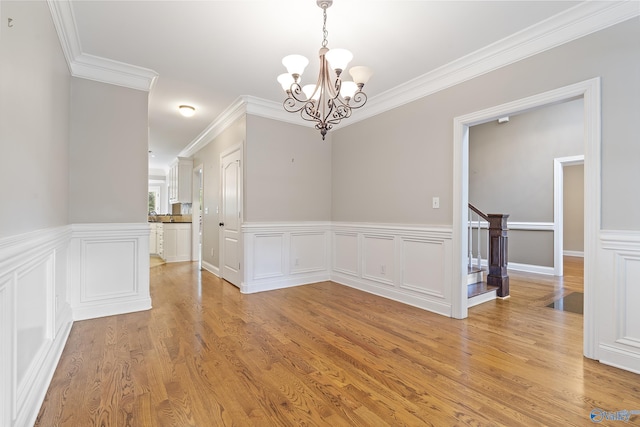 119 Railway Ln SE, Huntsville, AL 35803 - unfurnished dining area with a chandelier, ornamental molding, light wood-type flooring, stairs, and wainscoting