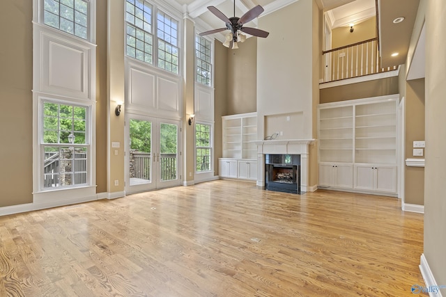 119 Railway Ln SE, Huntsville, AL 35803 - unfurnished living room featuring a high ceiling, built in features, light wood-type flooring, a fireplace, and baseboards