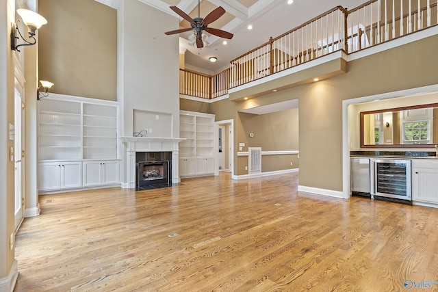 119 Railway Ln SE, Huntsville, AL 35803 - unfurnished living room featuring a high ceiling, beverage cooler, recessed lighting, a ceiling fan, and a tile fireplace
