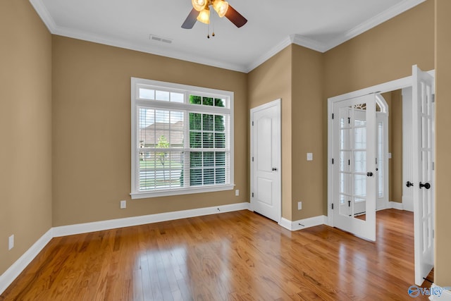 unfurnished room with ornamental molding, ceiling fan, light hardwood / wood-style floors, and french doors