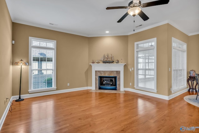 1006 Split Rock Cv, Huntsville, AL 35806 - unfurnished living room featuring visible vents, ornamental molding, light wood-style floors, baseboards, and a tiled fireplace