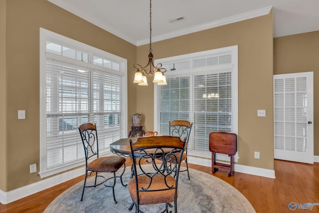 1006 Split Rock Cv, Huntsville, AL 35806 - dining space featuring crown molding, visible vents, an inviting chandelier, wood finished floors, and baseboards