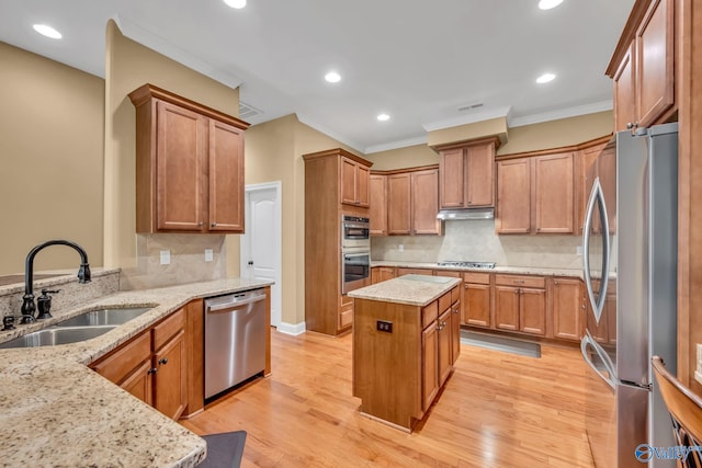 kitchen with sink, decorative backsplash, stainless steel appliances, light hardwood / wood-style flooring, and light stone countertops