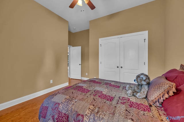 bedroom with ceiling fan, a closet, wood-type flooring, and lofted ceiling