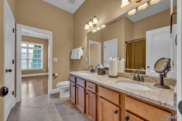 bathroom with hardwood / wood-style flooring, vanity, and toilet