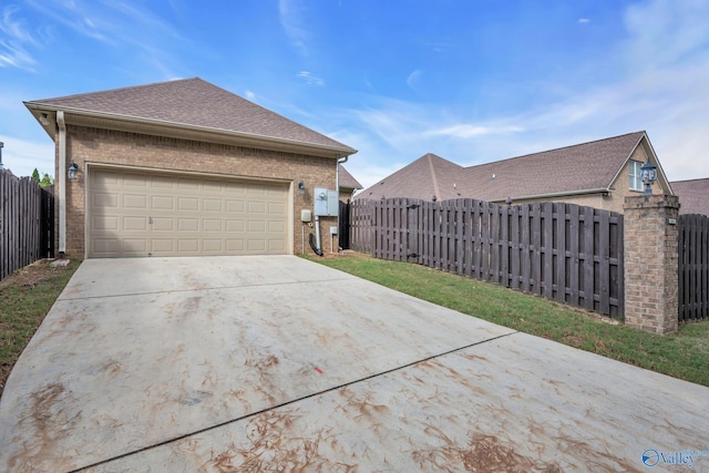 1006 Split Rock Cv, Huntsville, AL 35806 - view of side of property featuring brick siding, roof with shingles, driveway, and fence private yard