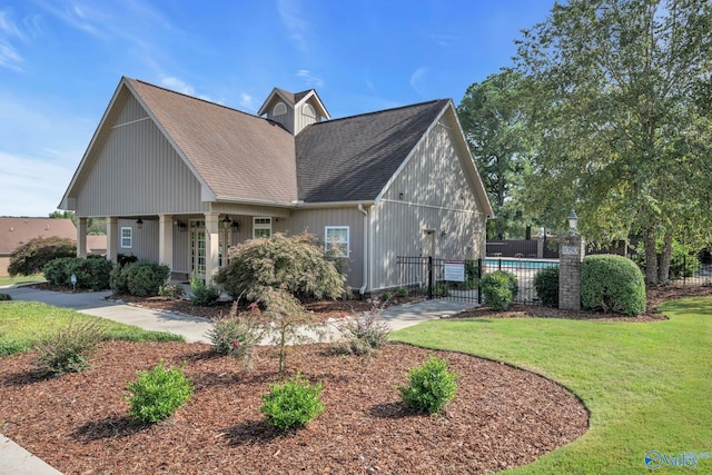 view of side of property featuring a lawn, a fenced in pool, and covered porch