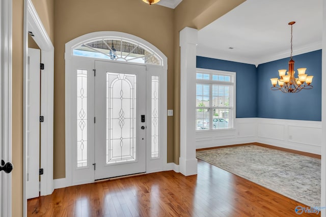 foyer entrance featuring a chandelier, hardwood / wood-style flooring, and crown molding