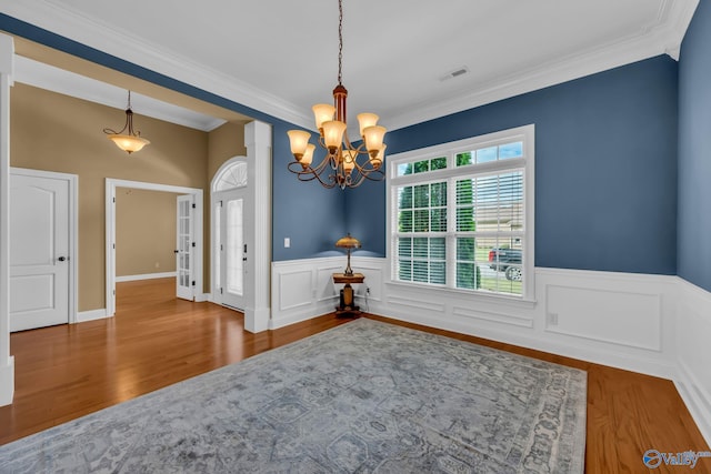 dining room with a notable chandelier, hardwood / wood-style flooring, and crown molding