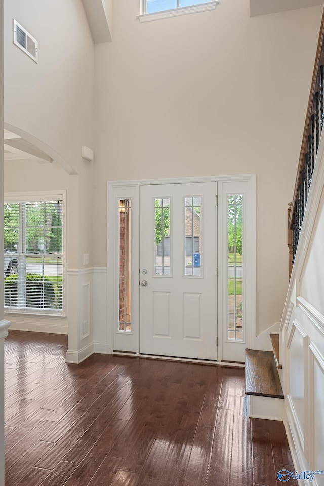 entrance foyer featuring a high ceiling, stairs, and visible vents
