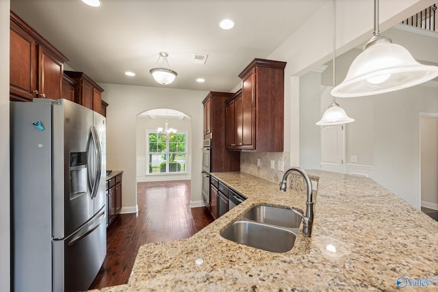 kitchen with visible vents, light stone countertops, dark wood-type flooring, a sink, and appliances with stainless steel finishes