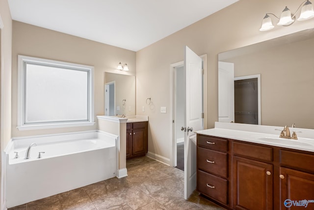 bathroom with a sink, a walk in closet, a bath, and two vanities