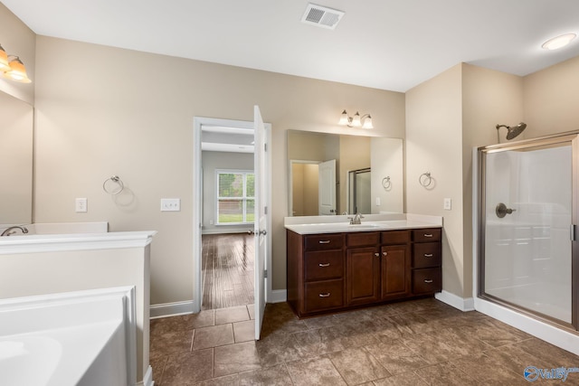 bathroom featuring vanity, baseboards, visible vents, and a stall shower