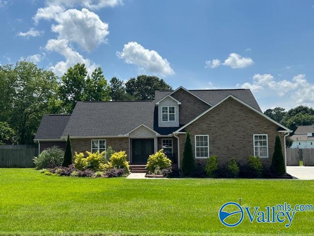 view of front of property featuring fence, a front lawn, and brick siding