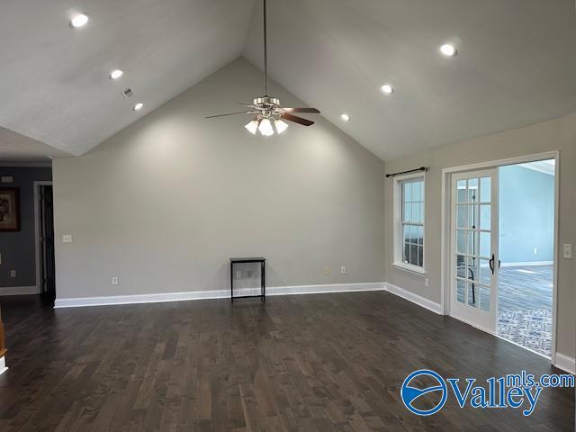 unfurnished living room featuring high vaulted ceiling, recessed lighting, dark wood finished floors, and baseboards