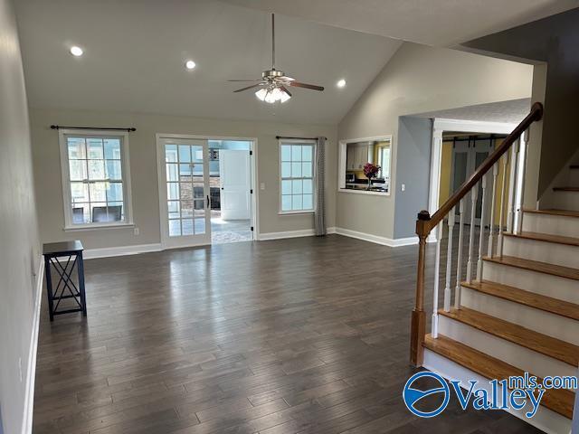 interior space featuring stairs, baseboards, dark wood finished floors, and a ceiling fan