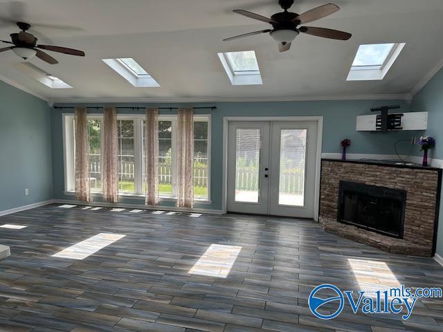 unfurnished living room featuring lofted ceiling, a ceiling fan, baseboards, dark wood-style floors, and crown molding