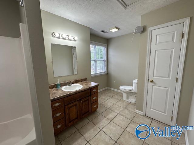 full bath featuring tile patterned floors, visible vents, toilet, vanity, and a textured ceiling