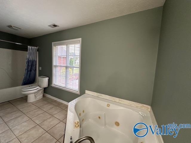 bathroom with baseboards, visible vents, tile patterned flooring, and toilet