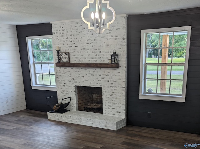 2537 Rexford St, Gadsden, AL 35903 - unfurnished living room with a chandelier, dark wood-style flooring, healthy amount of natural light, and wooden walls