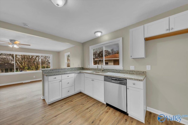 kitchen with dishwasher, a sink, white cabinets, and light stone countertops