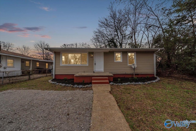 view of front of house featuring fence and a front lawn