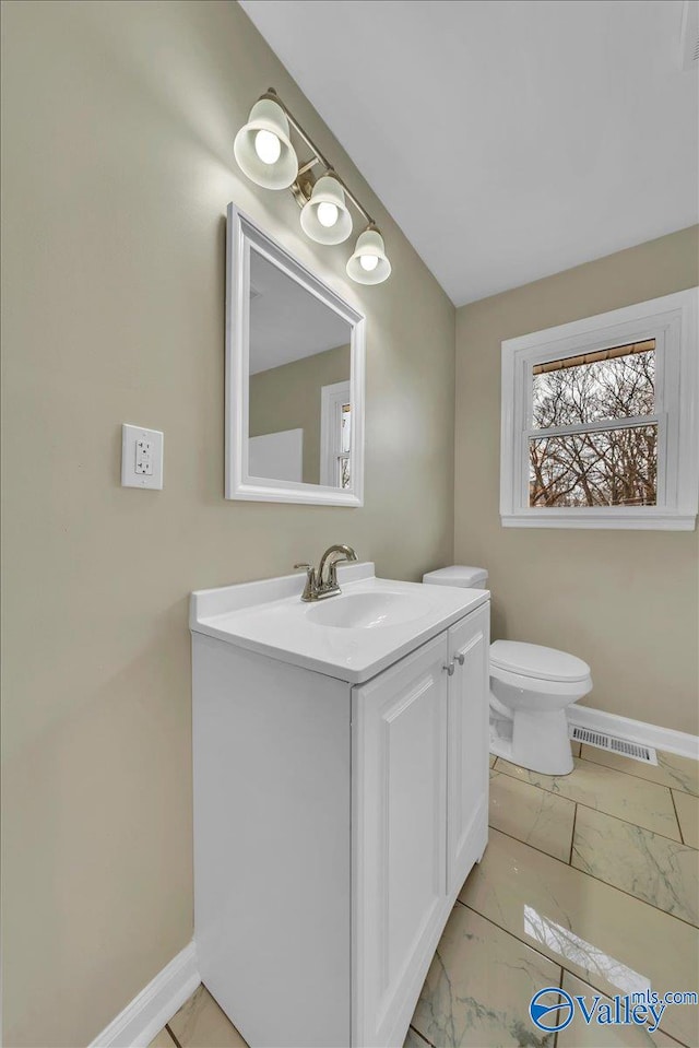 bathroom featuring toilet, baseboards, visible vents, and vanity