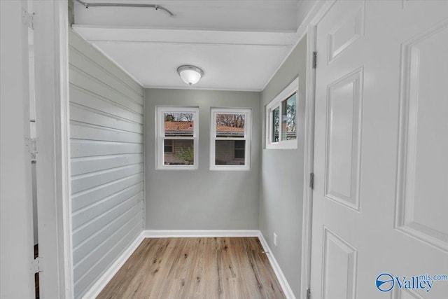 hallway featuring light wood-style floors and baseboards