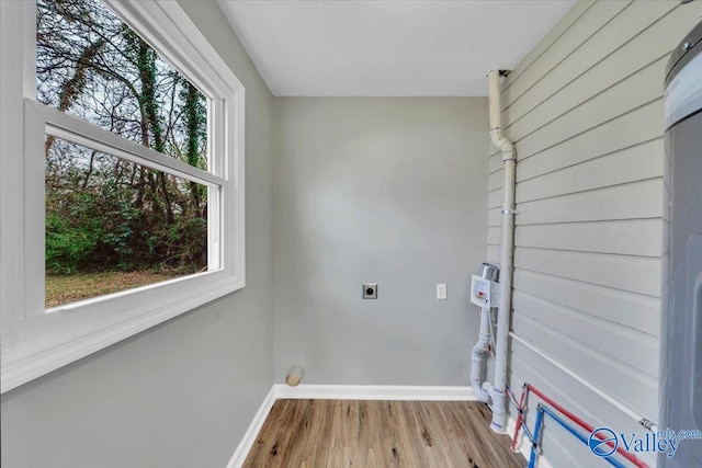 laundry room featuring laundry area, baseboards, hookup for an electric dryer, and wood finished floors