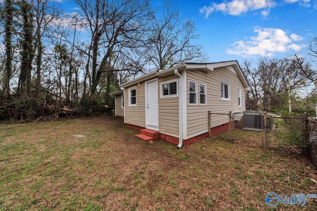 exterior space featuring entry steps, central AC unit, fence, and a gate