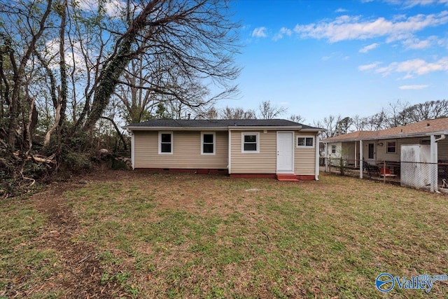 rear view of property featuring crawl space, fence, and a yard