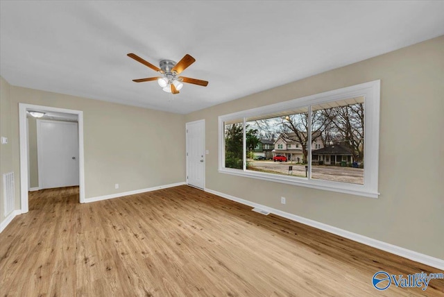 unfurnished living room with ceiling fan, wood finished floors, visible vents, and baseboards