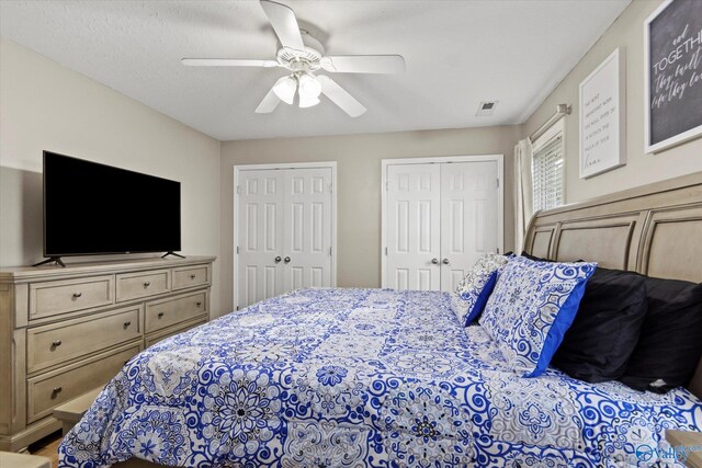 bedroom featuring two closets and ceiling fan