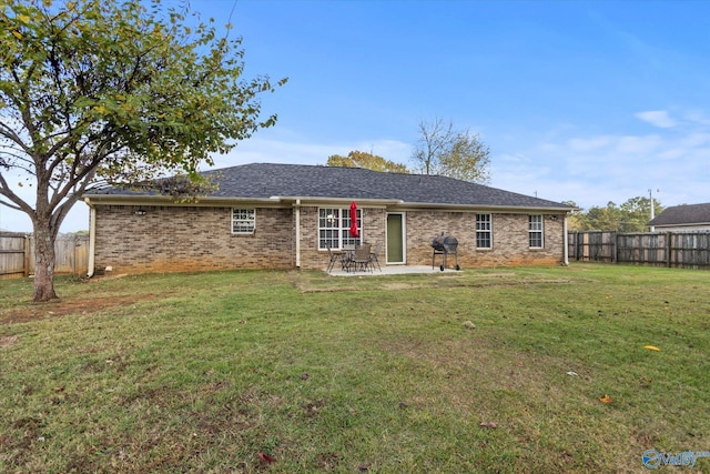 rear view of property with a lawn and a patio