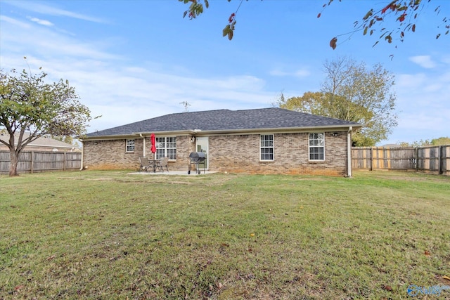 rear view of property featuring a lawn and a patio