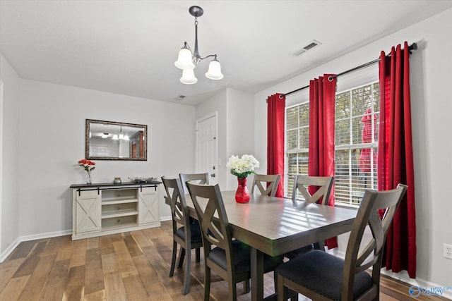 dining area featuring hardwood / wood-style floors and a notable chandelier