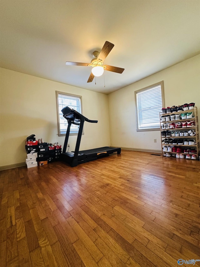 workout area featuring ceiling fan, hardwood / wood-style floors, and a healthy amount of sunlight