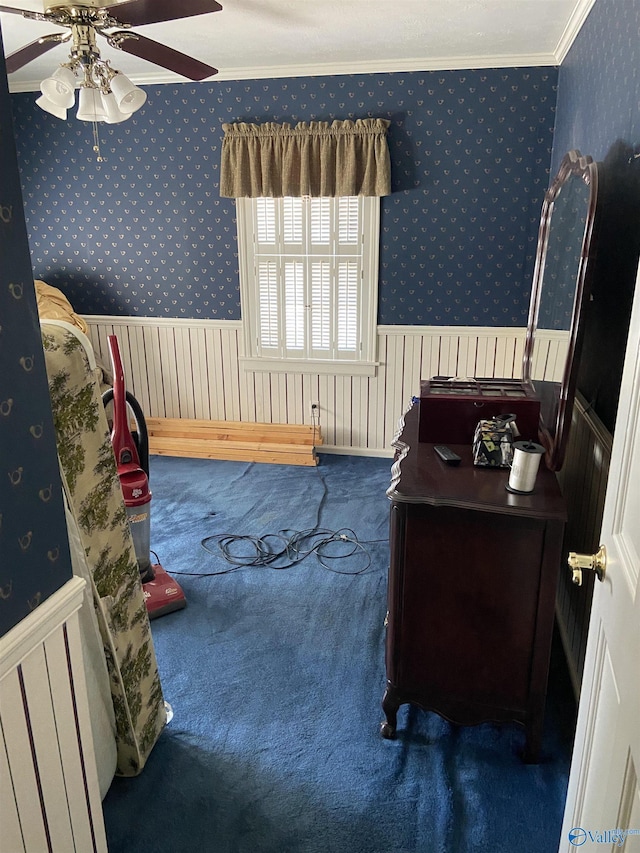 bedroom with wallpapered walls, crown molding, carpet, and a wainscoted wall