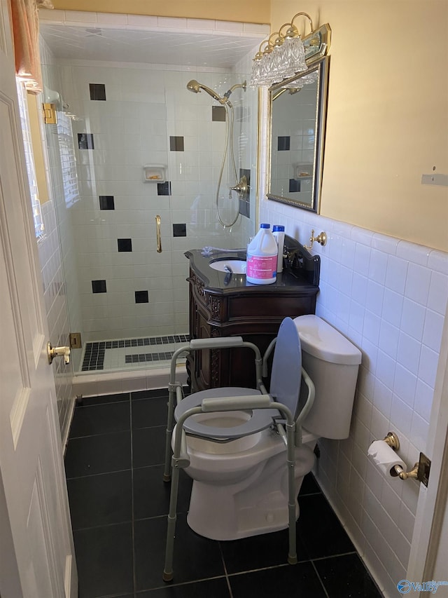 full bathroom featuring toilet, a wainscoted wall, tile patterned flooring, a shower stall, and tile walls