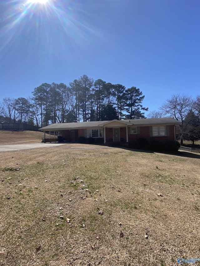 ranch-style home featuring a carport and a front yard