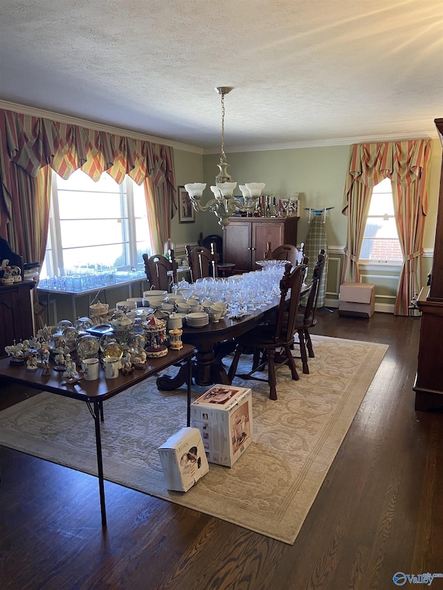 dining area featuring a wealth of natural light, ornamental molding, dark wood finished floors, and a notable chandelier