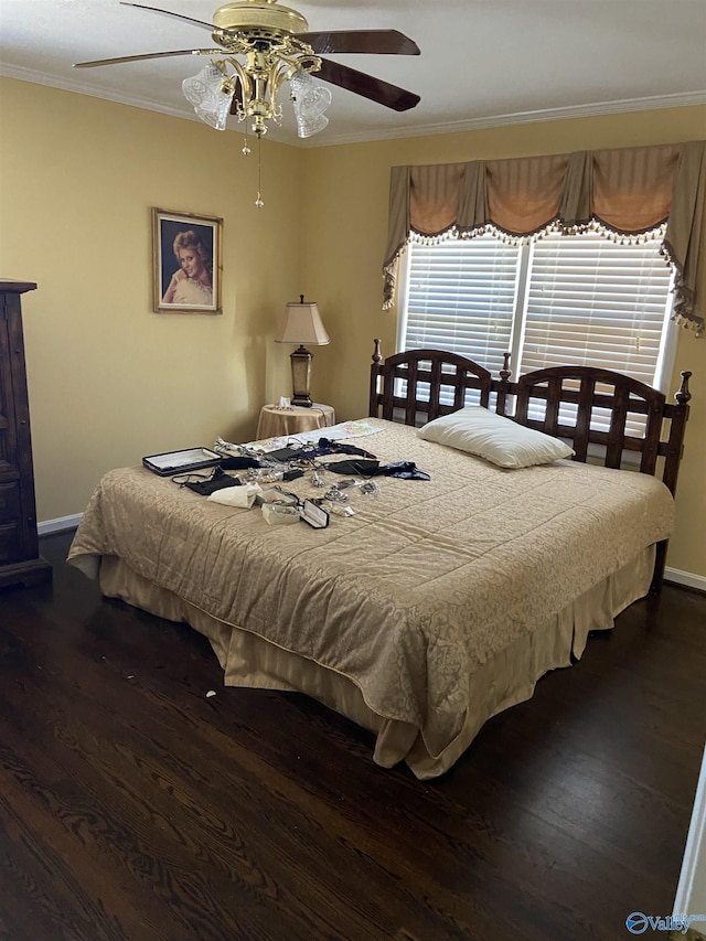 bedroom featuring dark wood-style floors, baseboards, ornamental molding, and a ceiling fan