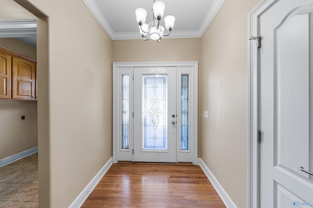 foyer with hardwood / wood-style flooring, crown molding, and a chandelier