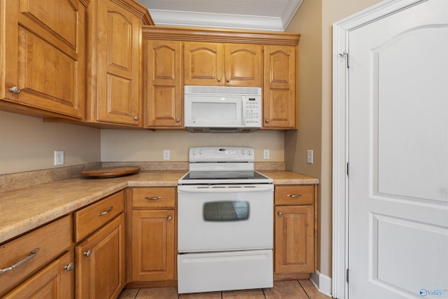 kitchen featuring ornamental molding, light tile patterned floors, and white appliances