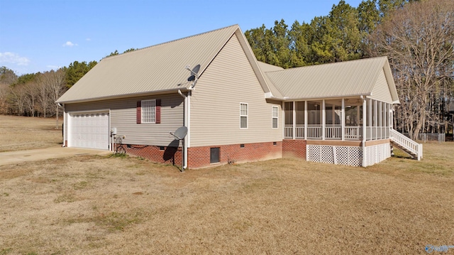 view of front facade featuring a garage, a sunroom, and a front yard