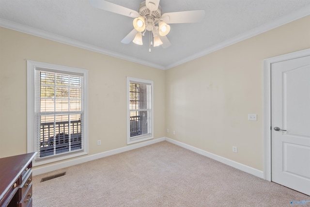 spare room featuring ceiling fan, light colored carpet, and ornamental molding