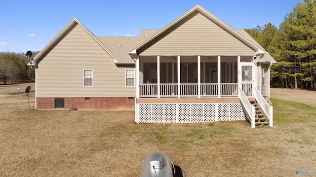 back of house featuring a sunroom and a lawn